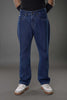 Man front view standing in dark blue slim fit jeans, neutral studio background.