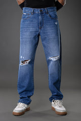 Underrated Club men's ripped distressed blue jeans knee rips slim fit model pose white sneakers urban fashion product photo.
