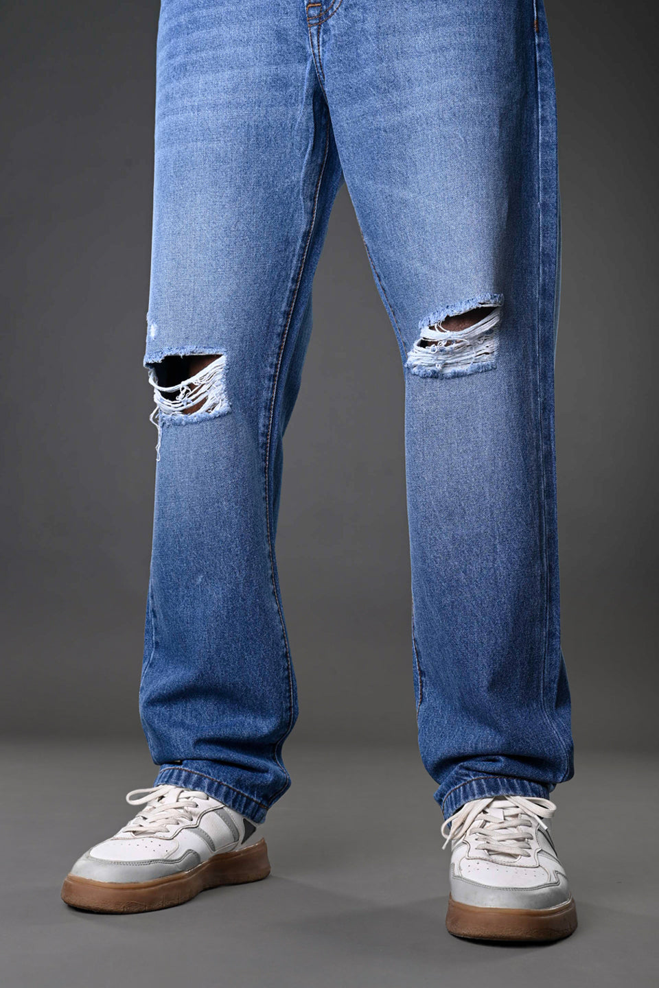 Underrated Club men's blue ripped jeans knee distressed holes closeup white sneakers casual denim fashion product zoom.

