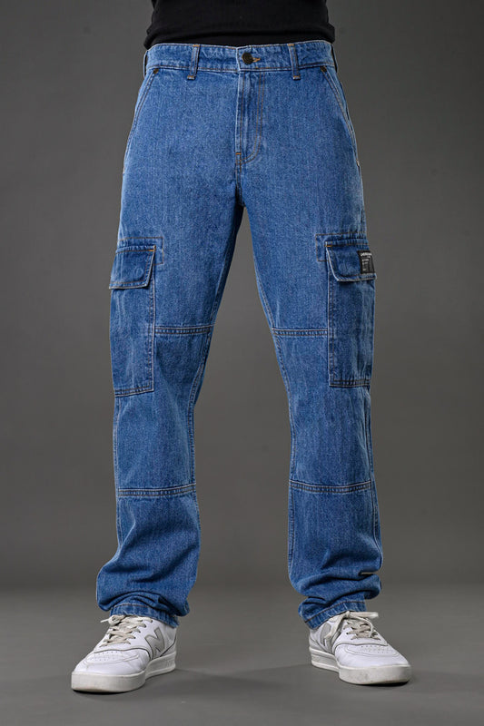 Underrated Club men's blue cargo baggy jeans front view flap pockets wide leg streetwear white Nike sneakers black tank urban fashion.
