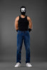 Full-body man wearing white smiley balaclava black tank top slim blue jeans white sneakers gray background.
