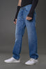 Side profile man posing light wash blue jeans black top cuffs white sneakers showcasing fit and stitching.
​

