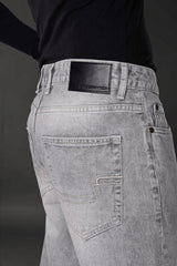 Grey denim jeans back pocket black leather Underrated Club label stitching detail men's fashion.
