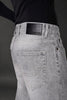 Grey denim jeans back pocket black leather Underrated Club label stitching detail men's fashion.
