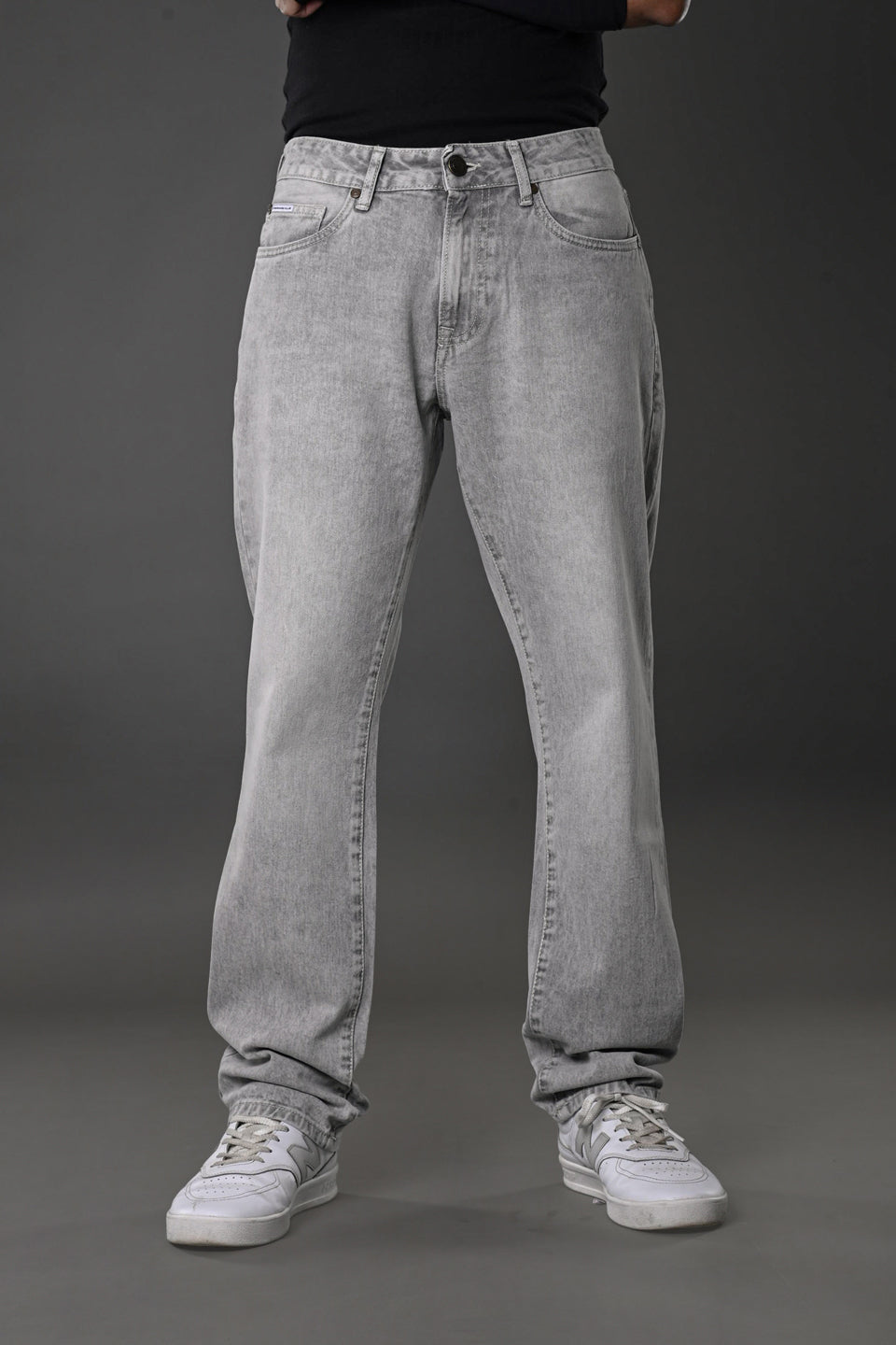 Underrated Club grey wash baggy jeans front full body model black top white sneakers casual fit urban vibe.
