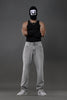 Underrated Club grey baggy jeans front model black balaclava tank top urban streetwear white sneakers.

