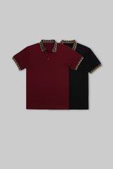 Flat lay of two solid polo shirts in maroon and black, each featuring subtle contrasting trim on the collars.