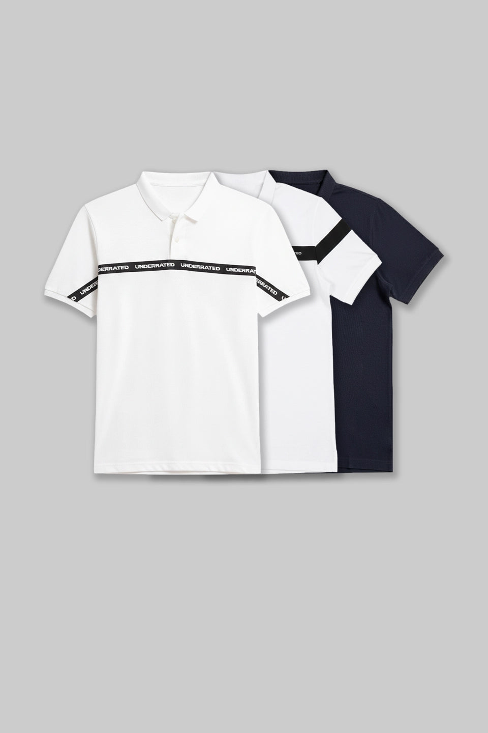 Flat lay of three folded polo shirts in white, navy blue, and black with a chest stripe design.