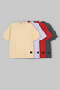 UNDERRATED oversized t-shirts quartet in beige, lavender, red, and grey colors with brand tags against grey background - men's streetwear basics.
