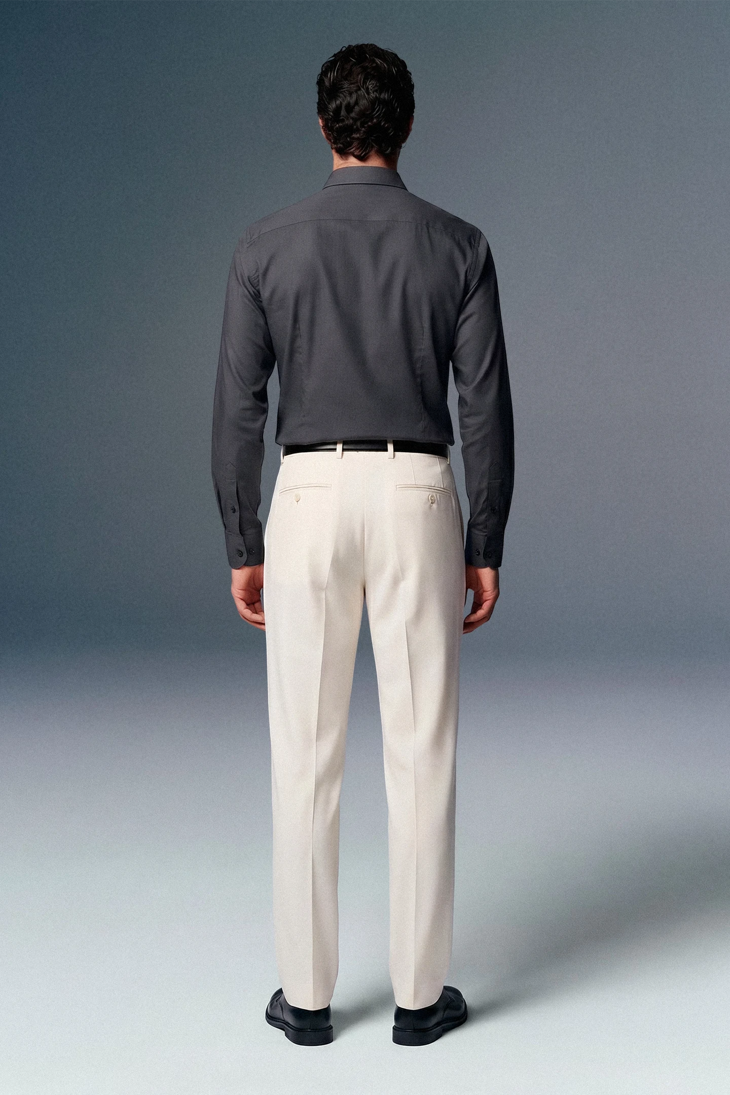 Man wearing a gray shirt and beige pants against a gray background