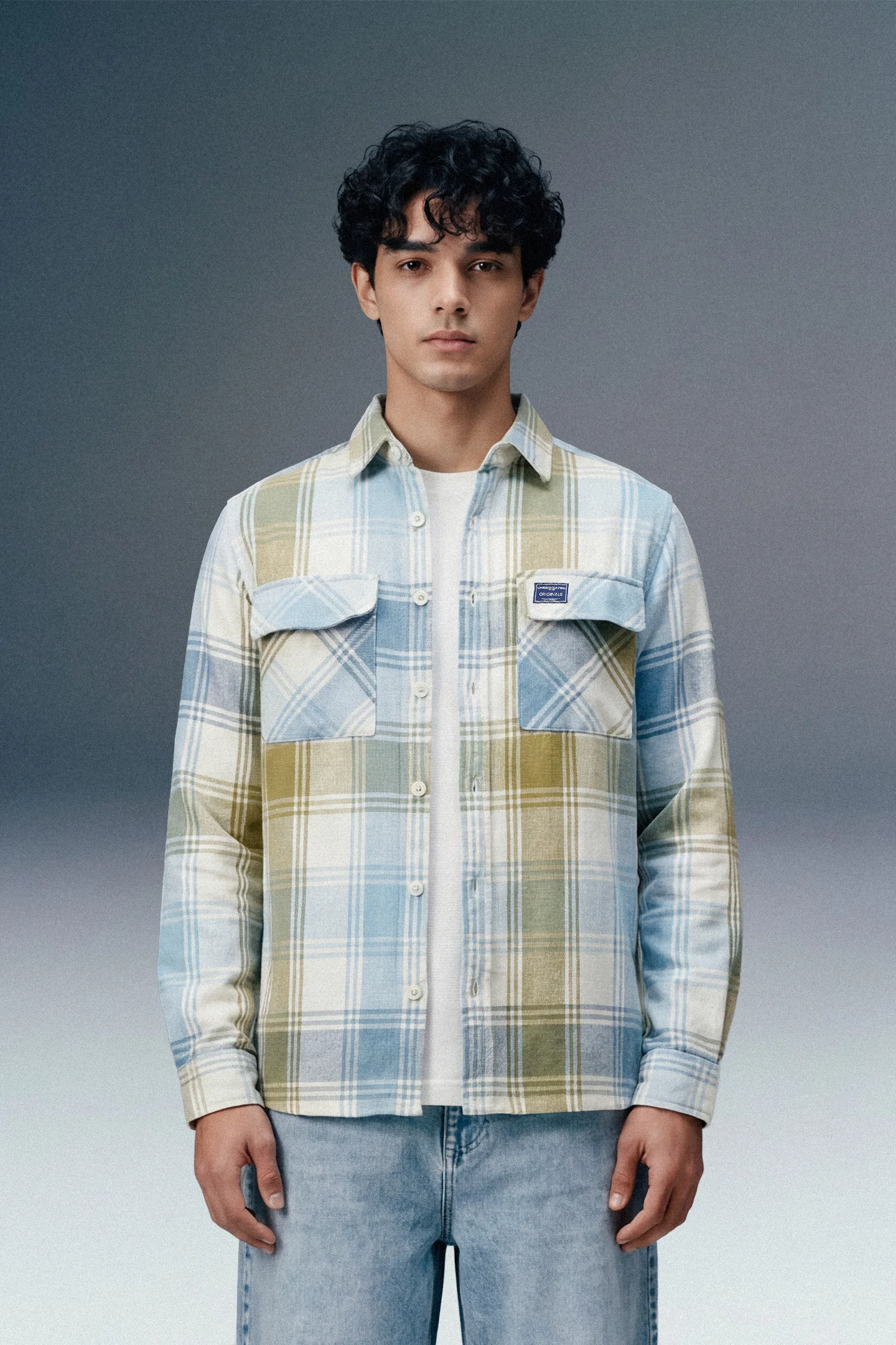 Man wearing a plaid shirt with a gray background