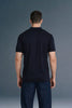 Full-length rear view of a man standing straight, showing the clean back fit of a solid navy blue polo shirt and dark blue trousers.