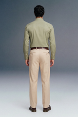 Man wearing a green shirt and beige pants against a gray background