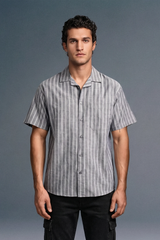 Man wearing a gray striped shirt against a gray background