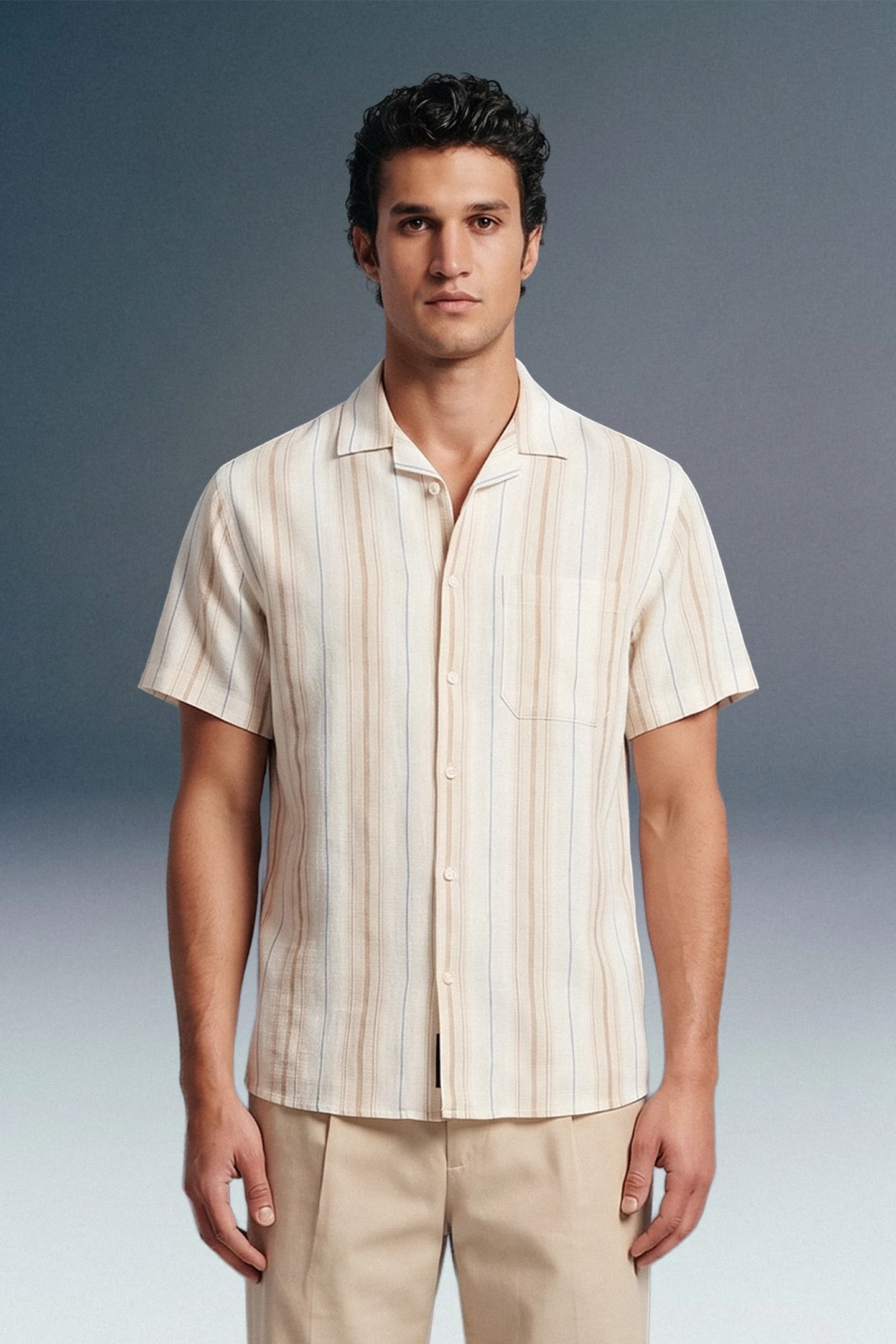Man wearing a beige striped shirt and pants against a gray background