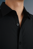 Close-up of a black shirt with a collar and buttons on a gray background