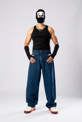 Person in a black tank top, baggy blue jeans, and a black balaclava with a white icon against a plain grey background.