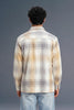 Person wearing a plaid shirt and jeans from behind on a gray background
