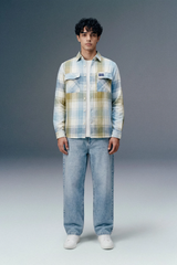 Person wearing a plaid shirt and jeans on a gray background
