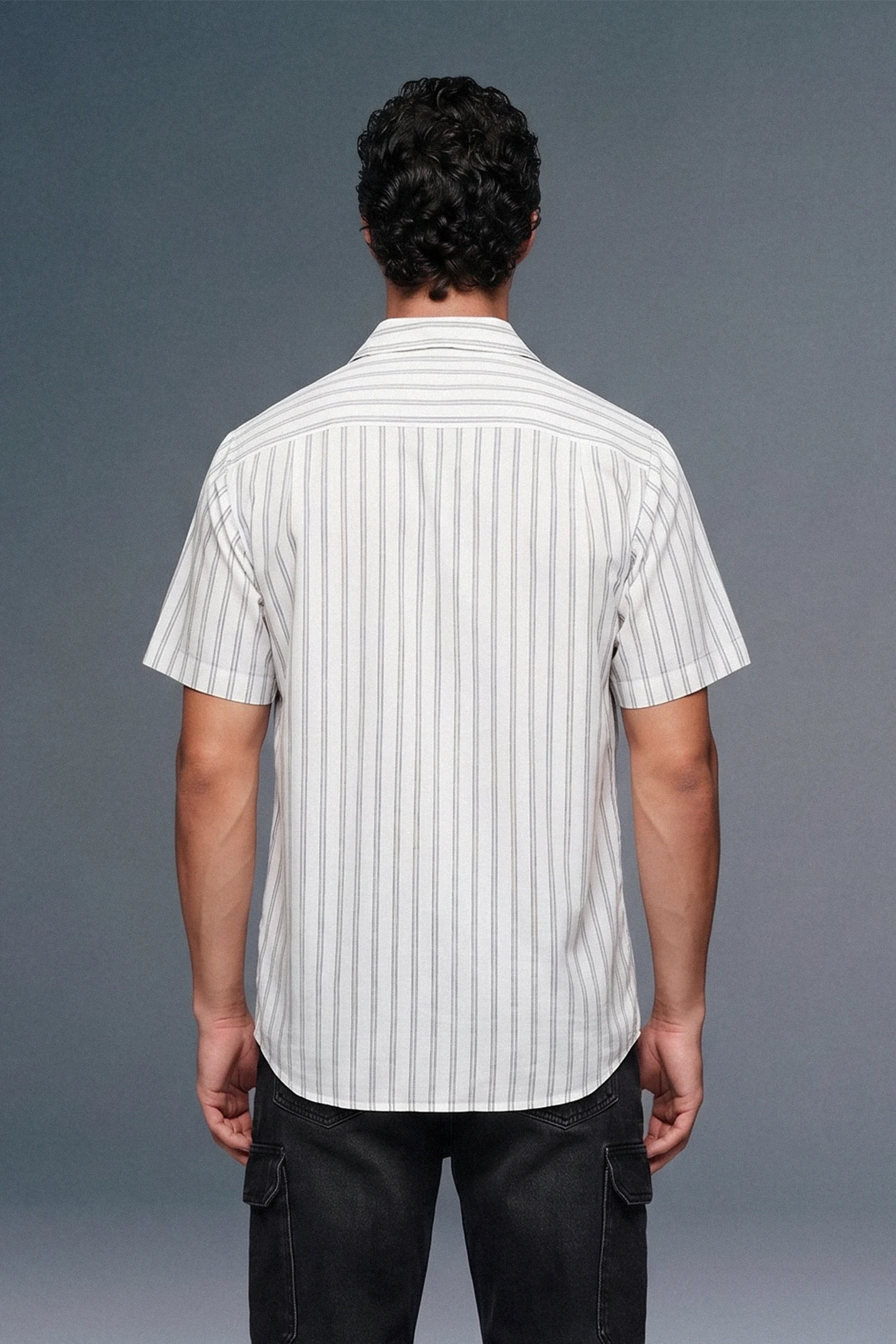 Man wearing a white striped shirt against a gray background