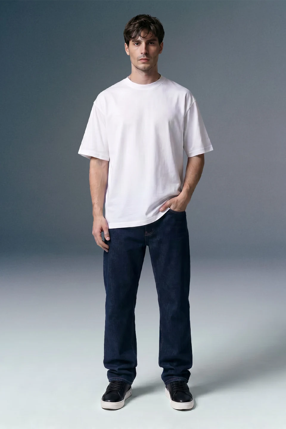 Man wearing a plain white t-shirt and dark pants on a gray background