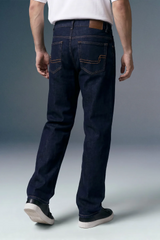 Person wearing dark blue jeans on a gray background