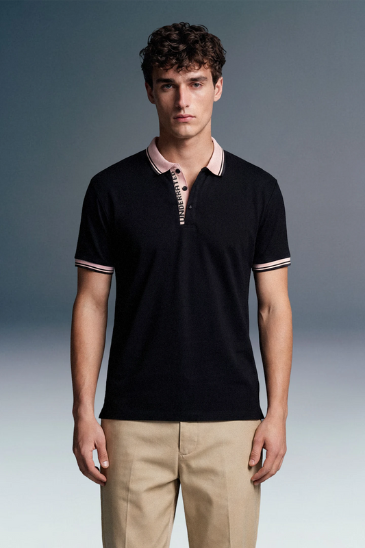 Full-length front view of a man standing facing forward, wearing an open-collar black polo shirt with beige detailing and khaki pants.