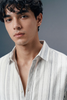 Man wearing a light-colored striped shirt against a gray background