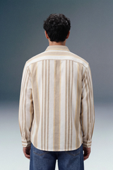 Man wearing a striped shirt from behind on a gradient background