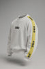 White sweatshirt with a high neck, black URC logo on the chest, and a bold yellow racing stripe on the sleeve with repeated black text.