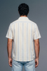 Person wearing a striped shirt and jeans against a gray background