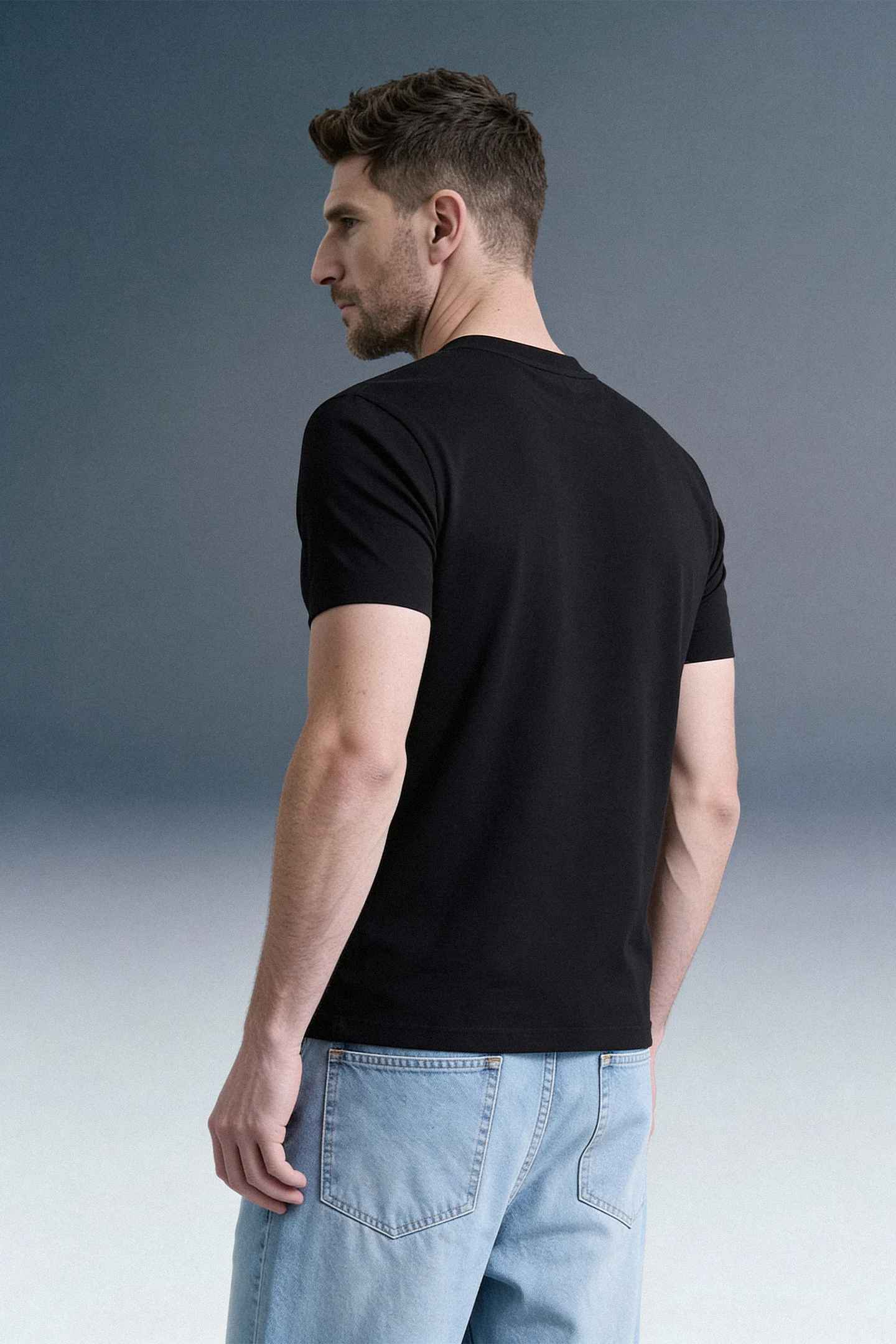 Back Side View of Men Wearing Black Oversized T-Shirt with Light Blue Jeans