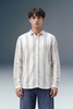 Man wearing a striped shirt and jeans against a gradient background
