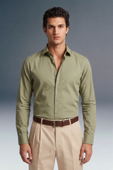 Man wearing a green shirt and beige pants against a gray background