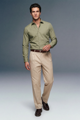 Man wearing a green shirt and beige pants on a gray background