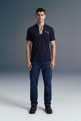 Front view from the waist up of a man looking forward, wearing a navy blue polo shirt with a contrasting beige or checkered inner placket and collar detailing.