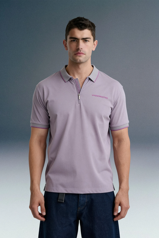Three-quarter front shot from the waist up of a man facing forward, wearing a light purple polo shirt that features a delicate pink contrast stripe along the collar edge.