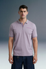 Three-quarter front shot from the waist up of a man facing forward, wearing a light purple polo shirt that features a delicate pink contrast stripe along the collar edge.
