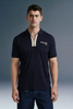 Front view from the waist up of a man looking forward, wearing a navy blue polo shirt with a contrasting beige or checkered inner placket and collar detailing.