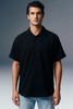 Man wearing a black short-sleeve shirt against a gray background