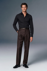 Man wearing a black shirt and brown pants against a gray background