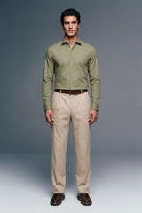 Man wearing a green shirt and beige pants against a gray background