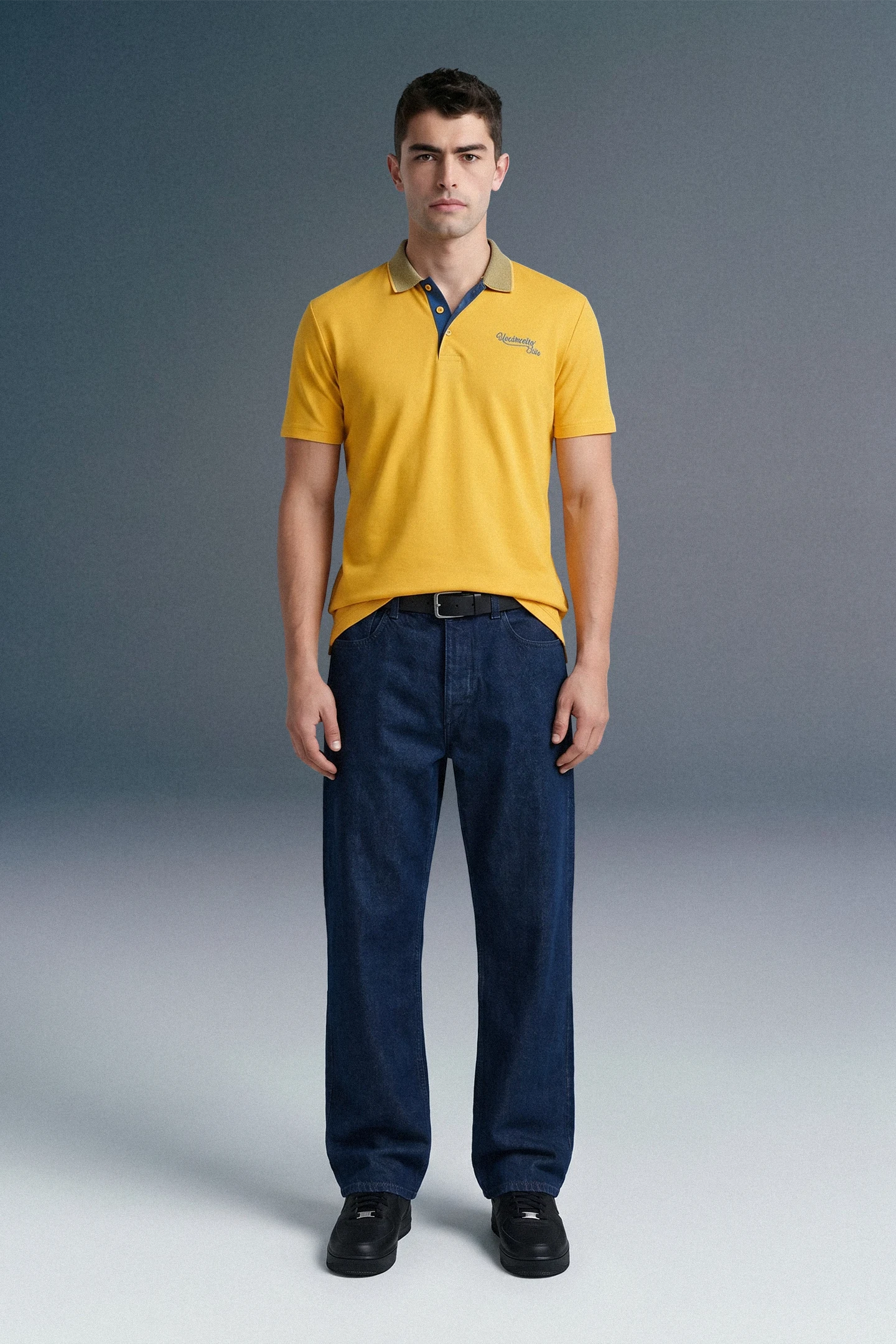 Full-length front view of a man standing straight, wearing a mustard yellow polo shirt with a patterned blue-and-white collar, paired with dark blue trousers.