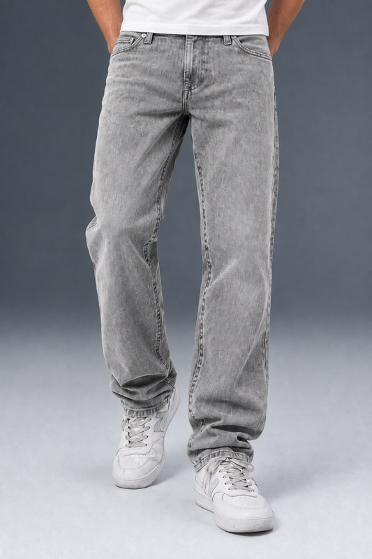 A person wearing light gray washed denim jeans with a straight-leg fit, paired with white sneakers and a white t-shirt, shown from the waist down against a gray studio background.